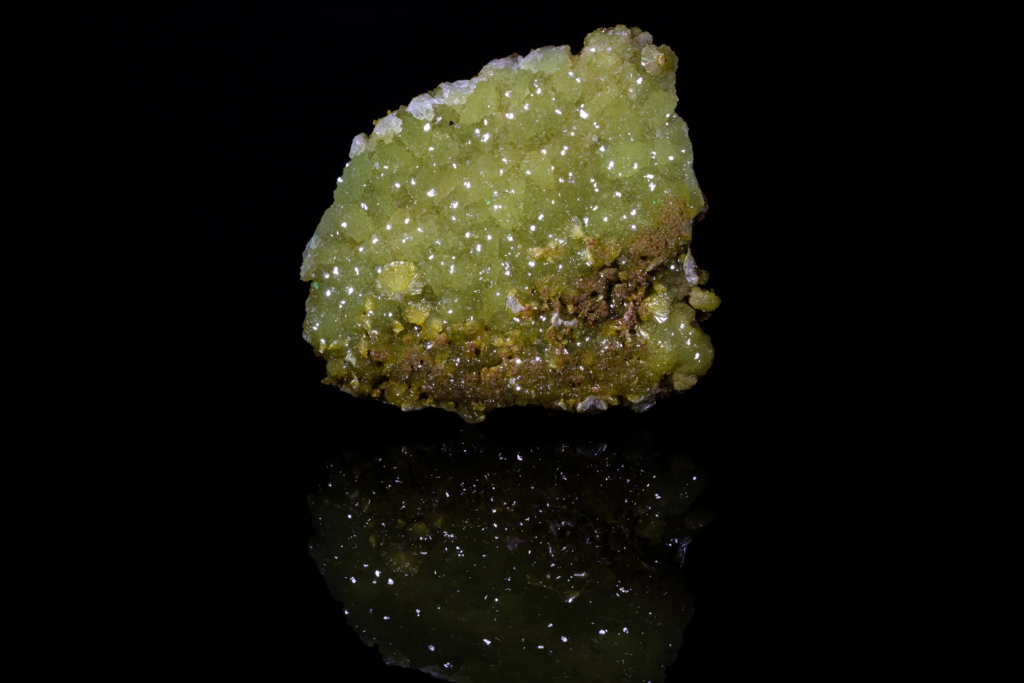 Yellowish green crystalline adamite specimen from Mexico with a sharp bottom reflection.