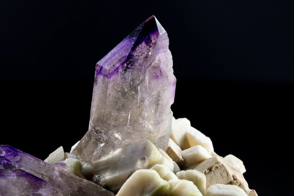 Macro of a single amethyst crystal tip with intense purple zoning.
