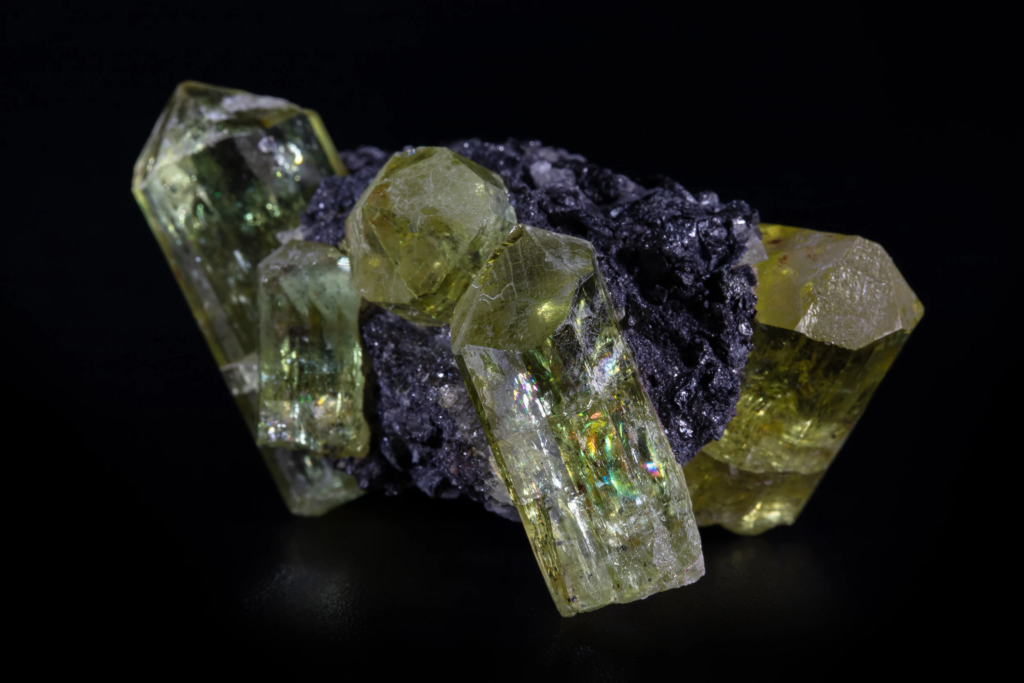 Yellow apatite crystals from Mexico showing internal rainbow iridescence reflections.