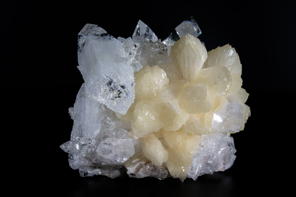Cream colored stilbite sheaf aggregates on apophyllite matrix from India.