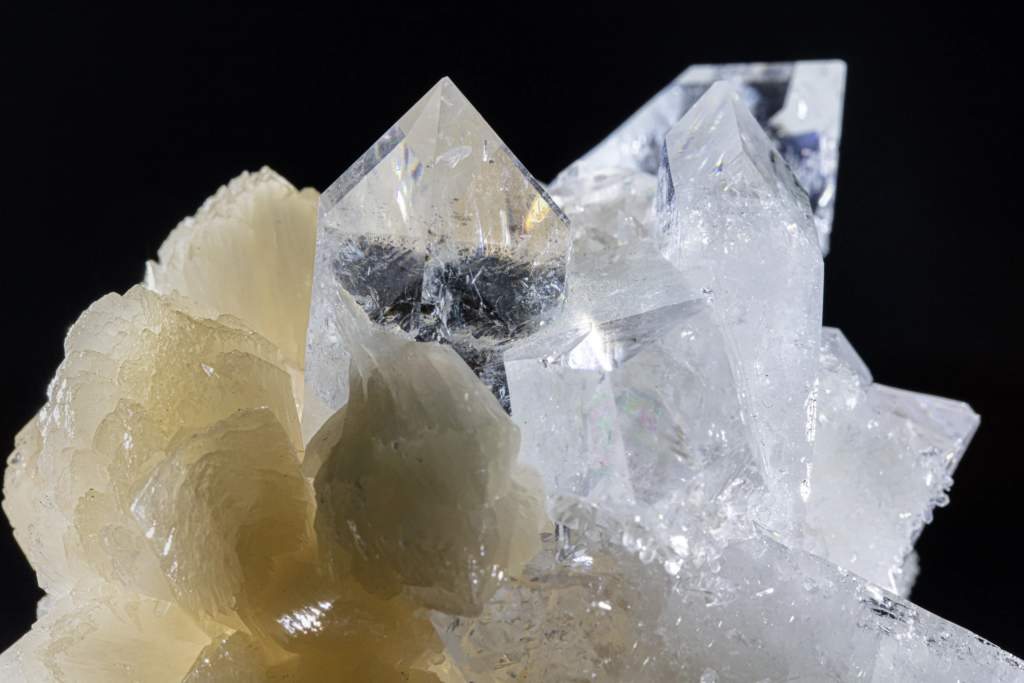 Cream stilbite cluster flanked by clear apophyllite crystals from India.