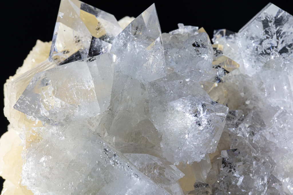 Close-up of cream stilbite bowties on transparent apophyllite from India.
