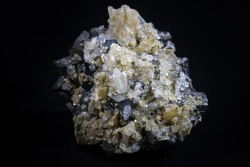 Clear calcite crystal group standing on metallic gray arsenopyrite from Kosovo.