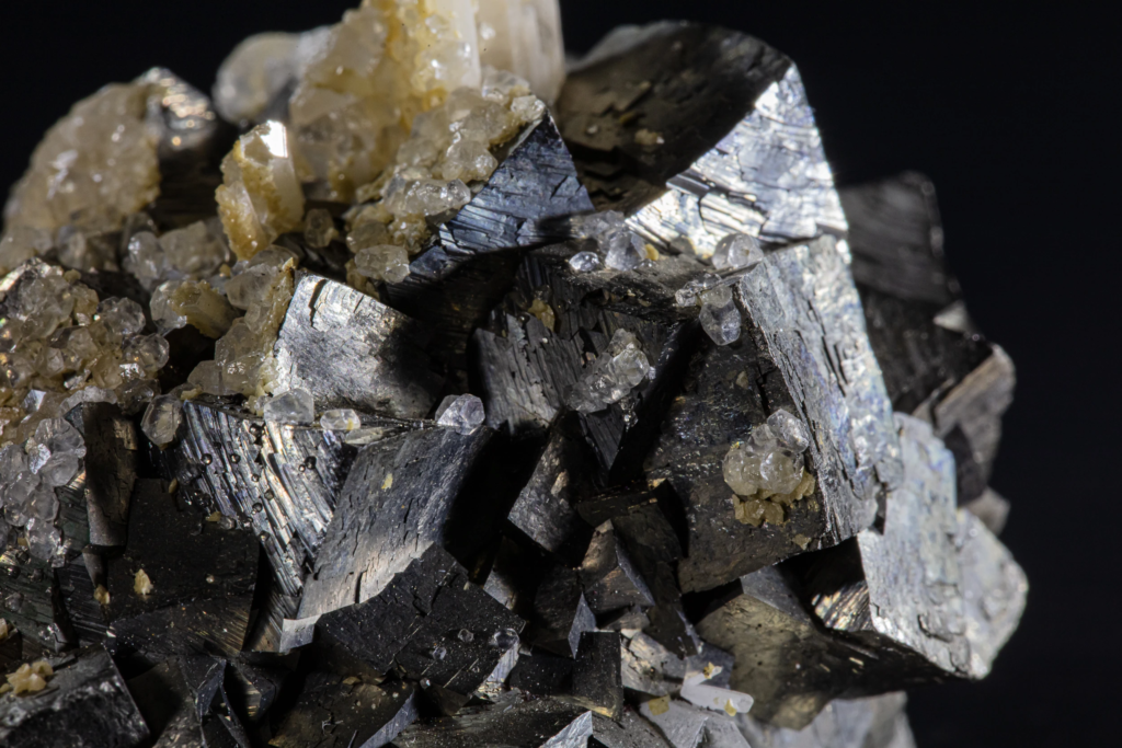 Complete arsenopyrite cluster capped by white calcite crystals from Kosovo.