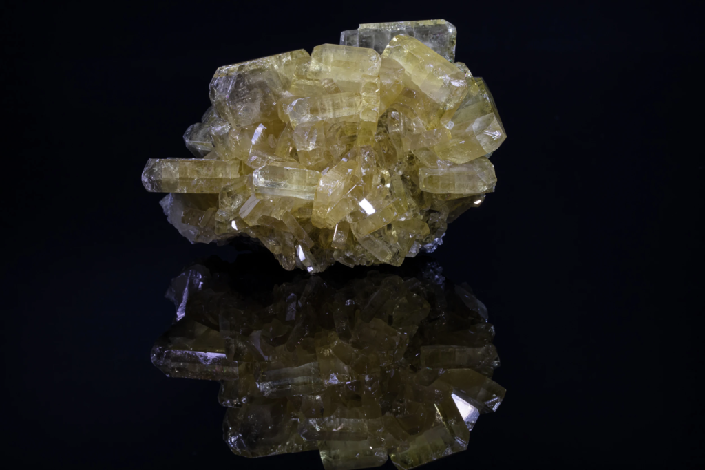 Yellow prismatic barite crystal cluster from the USA with mirror reflection.