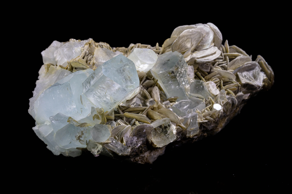 Macro of silvery muscovite mica plates between blue aquamarine crystals from Pakistan.