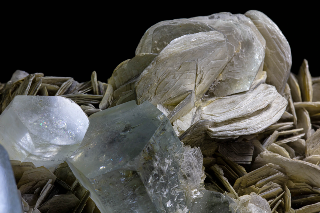 Micro photograph of tabular muscovite mica rosettes on pakistani aquamarine matrix.