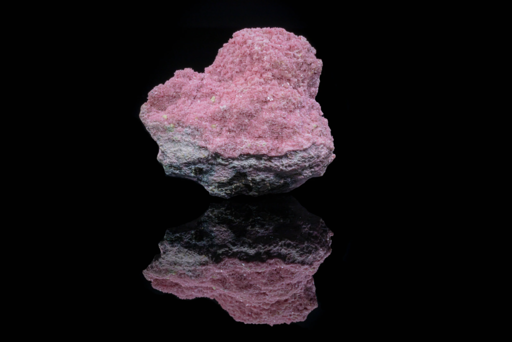 Brown axinite blades with pink rhodonite from Peru with mirror reflection.