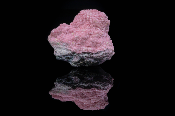 Brown axinite blades with pink rhodonite from Peru with mirror reflection.