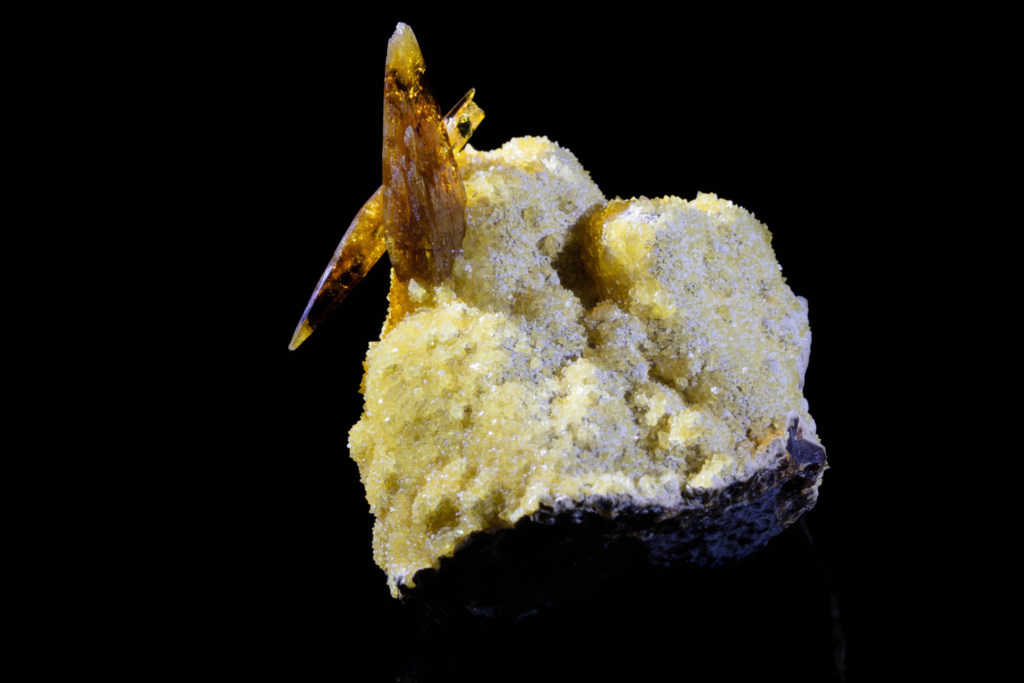 Amber barite crystals on white calcite matrix from the USA with reflection.