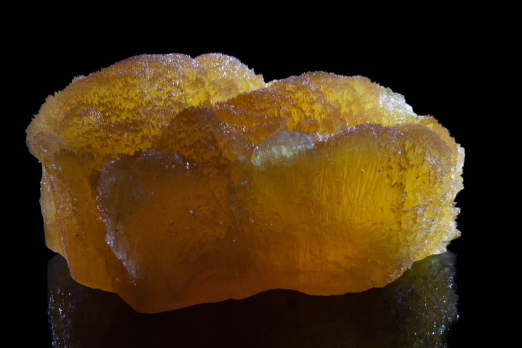 Close view of a glowing amber yellow calcite aggregate from France.
