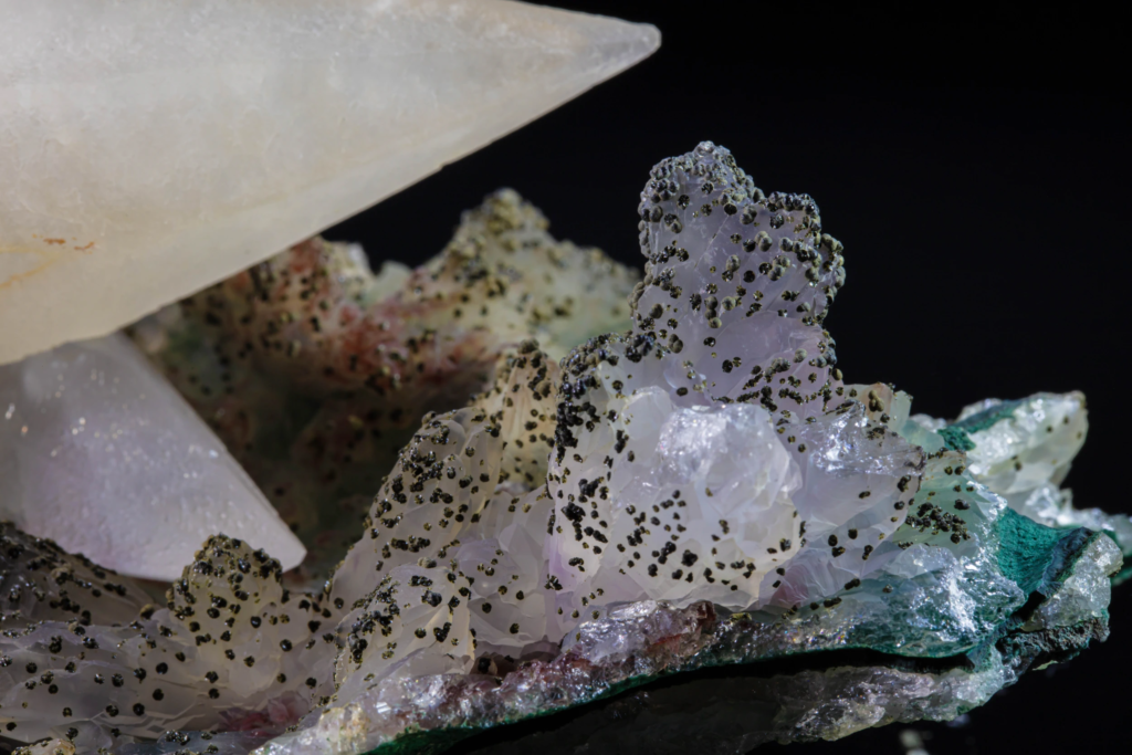 Macro of quartz matrix with black inclusions and green malachite, Brazil.