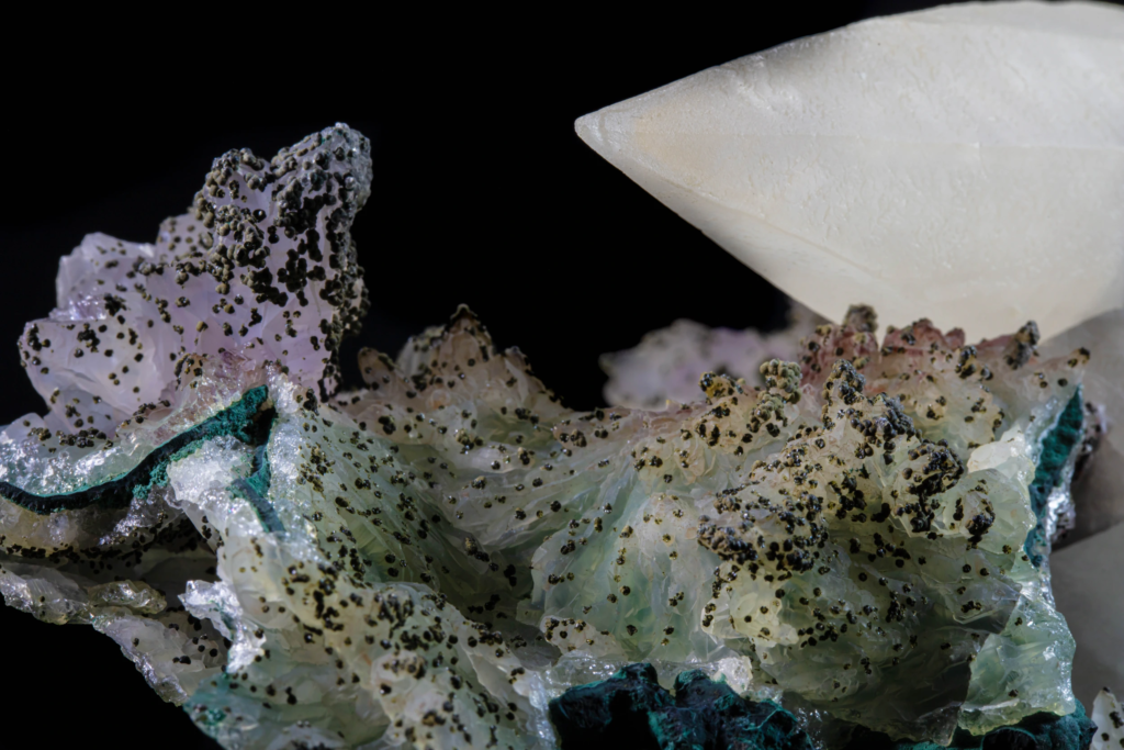 Macro of pale green crystalline druse with black mineral dots, Brazil.
