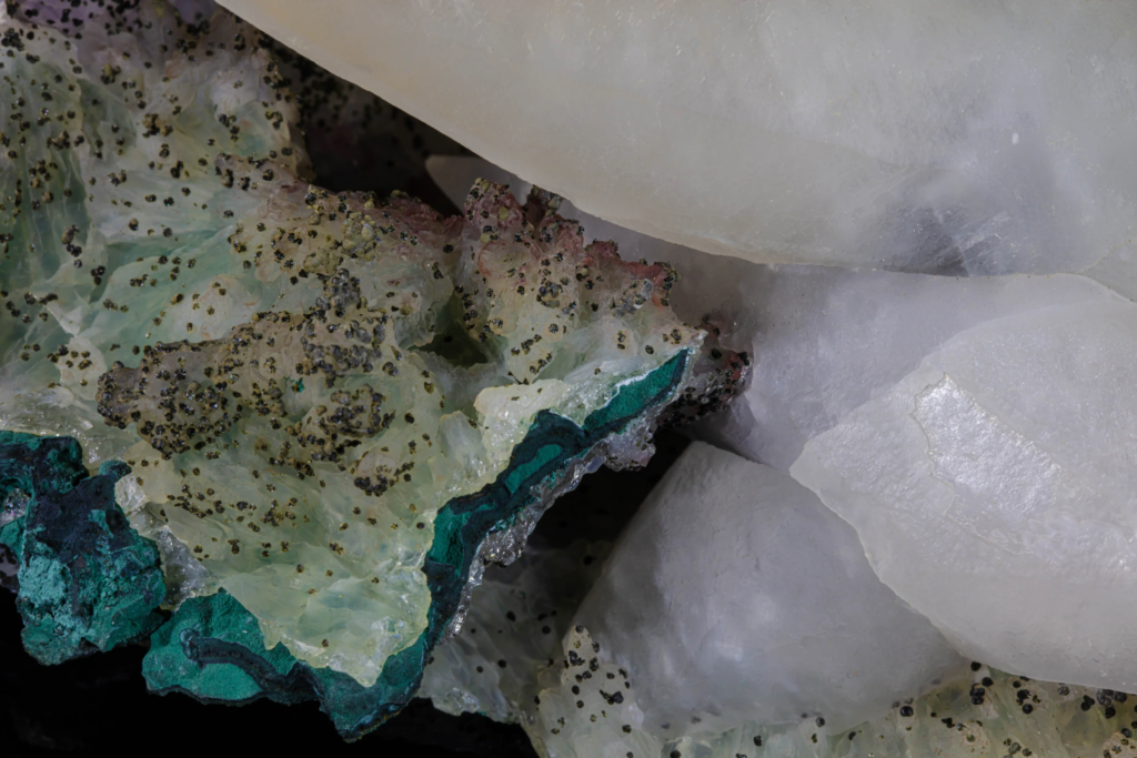 Macro view of white calcite face joining a green malachite matrix.