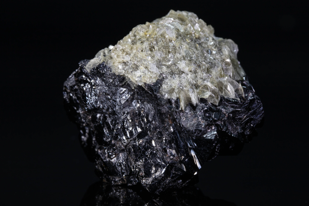 Reverse view of a highly lustrous black cassiterite matrix with muscovite.