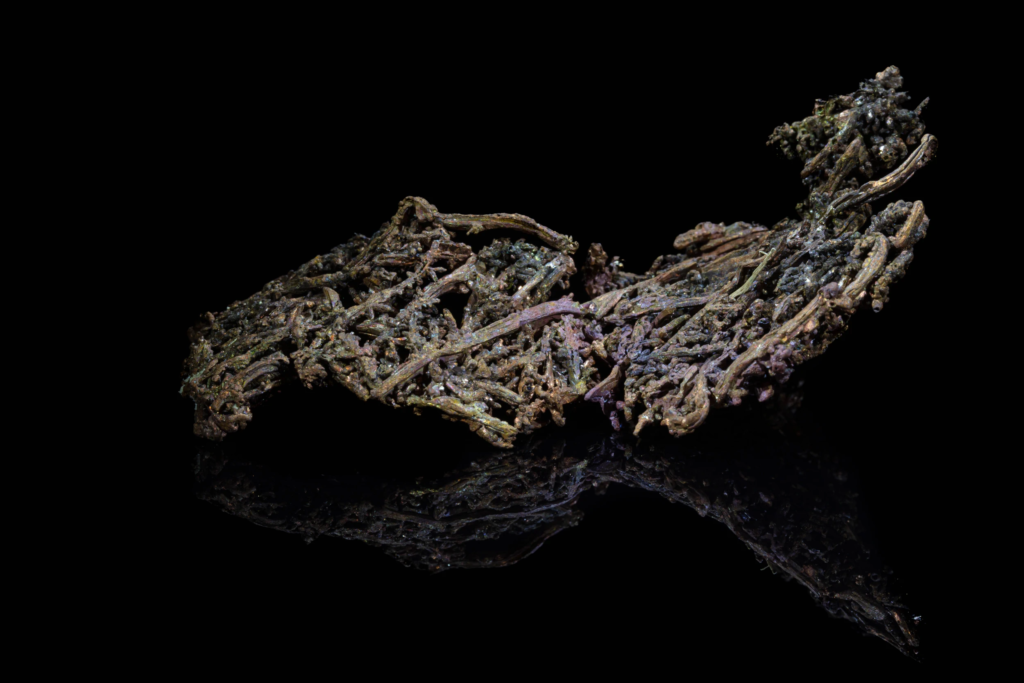 Dark oxidized dendritic native copper specimen from China with reflection.