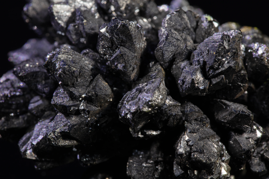 Macro photograph of dark descloizite crystals displaying subtle iridescent sheen.