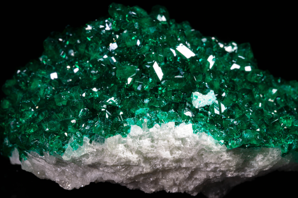 Detailed macro shot of green dioptase crystals over white matrix