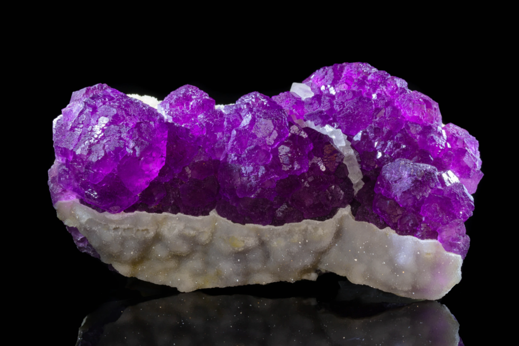 Close front view of a dense purple fluorite crystal cluster.