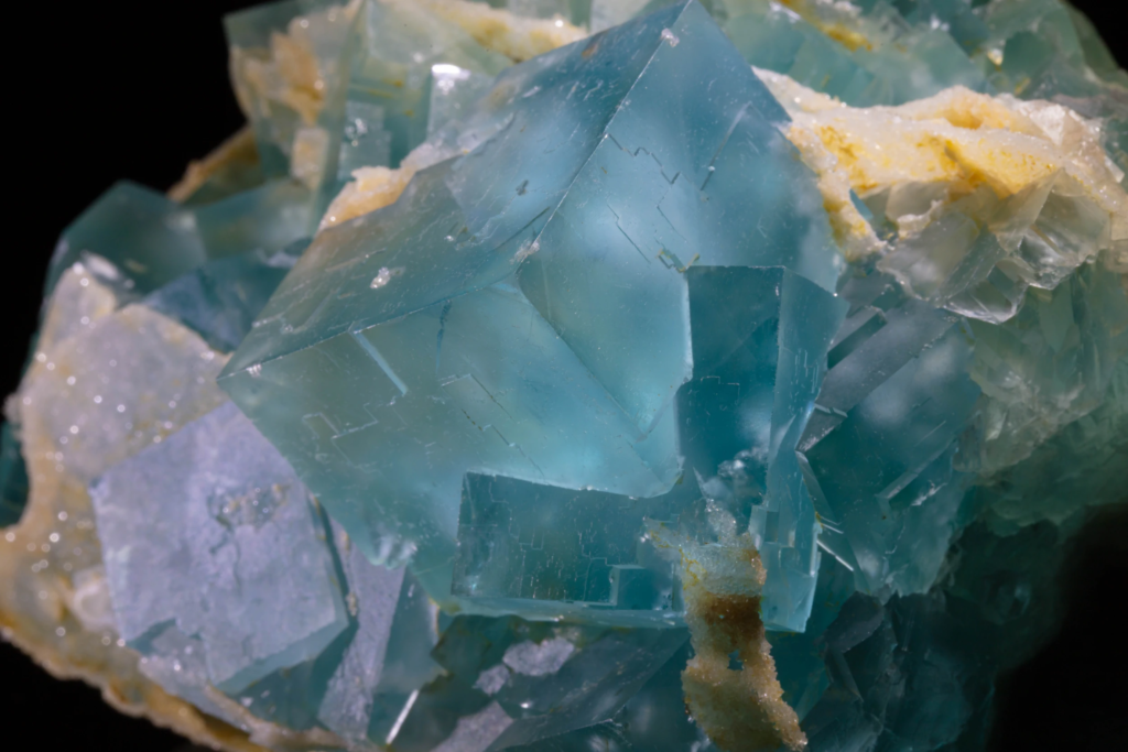 Macro photograph showing stepped growth lines on blue fluorite cubes.