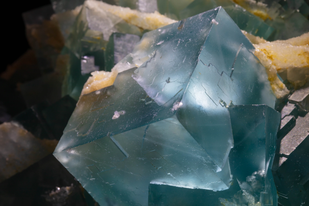Close macro view of geometric blue fluorite faces reflecting light.