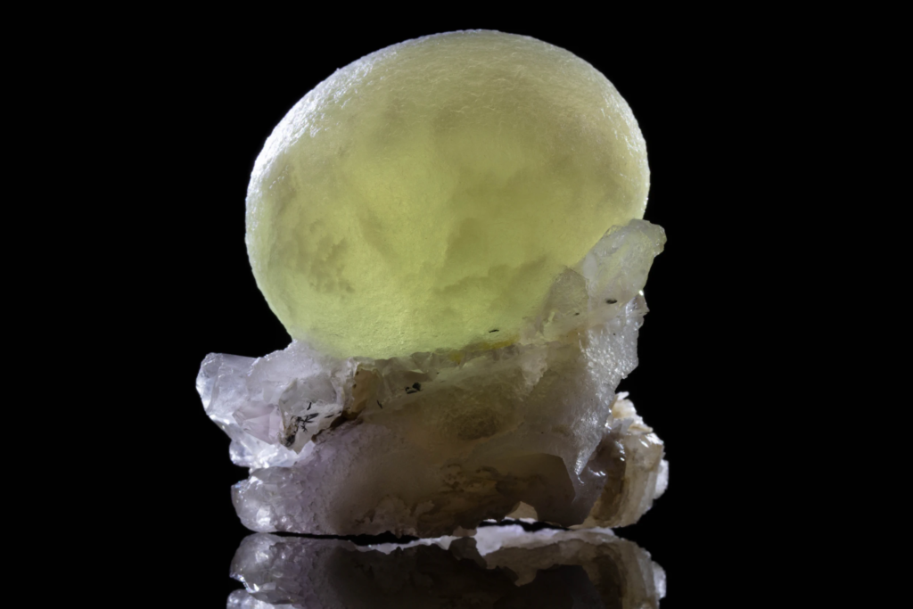 Translucent yellow spherical fluorite specimen on white crystalline quartz matrix.