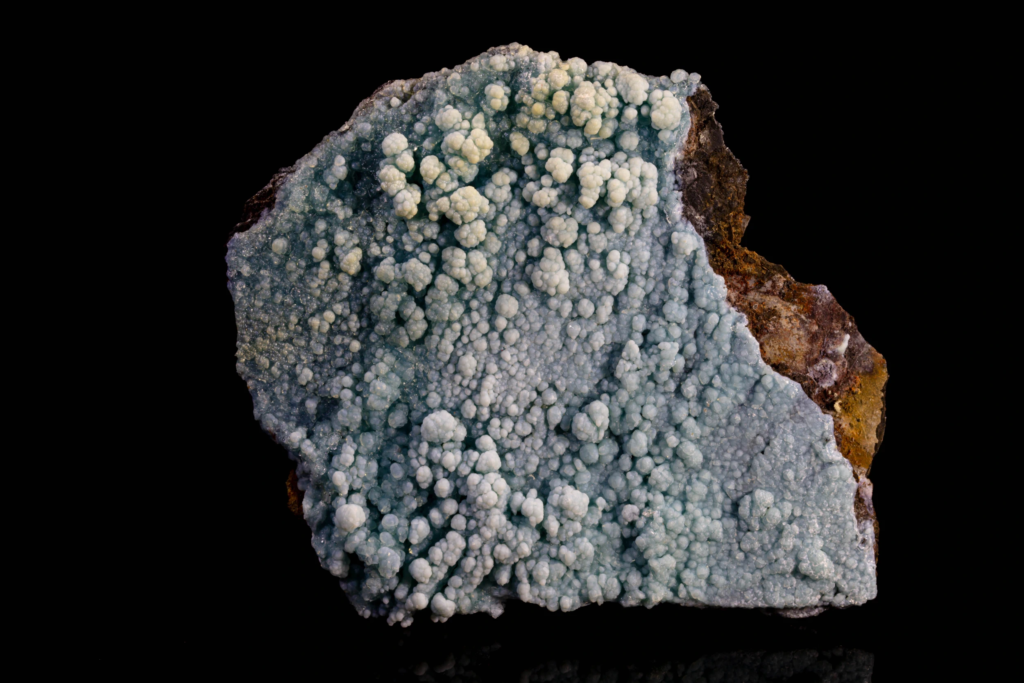 Light blue botryoidal gibbsite crust coating a dark brown matrix.
