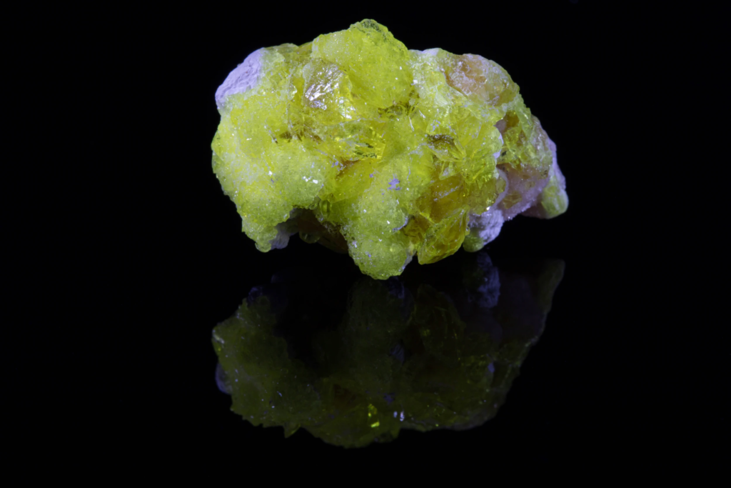 Upright view of lemon yellow jouravskite cluster displaying mirror reflection.